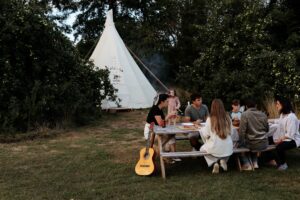 people outside of their tipi glamping