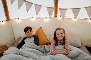 children in the bed in the glamping tipi